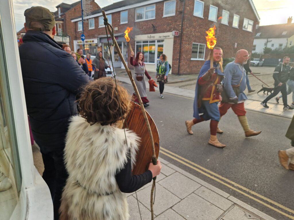 Our son surveys the parade in his gilet, with bow and shield at the ready...